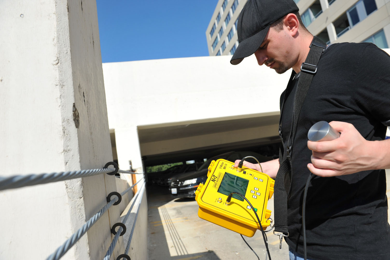 Digital Ultrasonic Pulse Velocity Tester with piezoelectric transducers and display in use